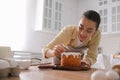 Young woman decorating traditional Easter cake with sprinkles in kitchen, space for text Royalty Free Stock Photo