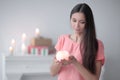 Young woman with a decorative candle on a background of a bright living room