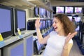 Young woman in delight looks at TVs in shop Royalty Free Stock Photo