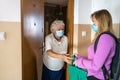 Young woman delivering groceries to her elderly grandmother