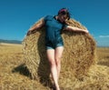 Young woman in denim clothes posing on hayfield Royalty Free Stock Photo