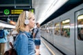 Young woman in denim shirt at the underground platform, waiting Royalty Free Stock Photo