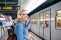 Young woman in denim shirt at the underground platform, waiting Royalty Free Stock Photo