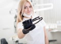 Portrait of young attractive female dentist holding dental tool at the modern dental office Royalty Free Stock Photo