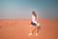 Young woman in desert. Tourist in Dubai desert on clear sky background.