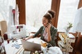 Young woman designer discussing new project. Young woman near sewing machine Royalty Free Stock Photo