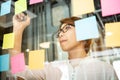 Young woman designer writing new ideas at sticky notes Royalty Free Stock Photo