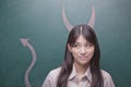 Young woman with devil horns and tail on blackboard Royalty Free Stock Photo