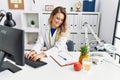 Young woman dietician smiling confident using computer at clinic