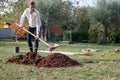 Young woman digging a hole with a shovel for a young tree