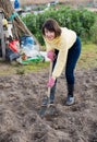 Young woman digs beds in the garden