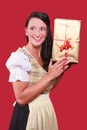 Young woman with dirndl and a great gift in hand Royalty Free Stock Photo