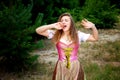 Young woman in dirndl standing outdoors and is yawning Royalty Free Stock Photo