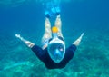 Young woman diving underwater photo. Snorkel in coral reef of tropical sea. Young girl in full-face snorkeling mask Royalty Free Stock Photo