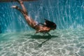 Young woman diving underwater in a pool. summer and fun lifestyle Royalty Free Stock Photo