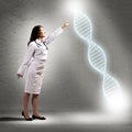 Young woman doctor finger glowing DNA symbol