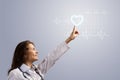 Young woman doctor finger glowing heart symbol Royalty Free Stock Photo