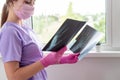 Young woman doctor looking at xray radiography images at clinic. Physician, surgeon reviewing scan of patient bones