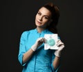 Young woman doctor nurse in blue uniform and protective latex gloves demonstrates special medical tools she holds