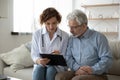 Young woman doctor nurse consulting mature patient during homecare visit Royalty Free Stock Photo