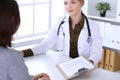 Young woman doctor and patient at medical examination in hospital office. Khaki colored blouse of therapist looks good Royalty Free Stock Photo