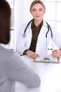 Young woman doctor and patient at medical examination in hospital office. Khaki colored blouse of therapist looks good