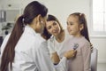 Young woman doctor pediatrician in medical uniform examining little smiling girl with stethoscope Royalty Free Stock Photo