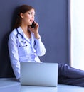 Young woman doctor sitting with your phone Royalty Free Stock Photo