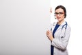 Young woman doctor with stethoscope and headphones with a blank billboard in white uniform on white background Royalty Free Stock Photo