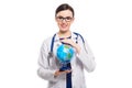 Young woman doctor with stethoscope holding a world globe in her hands in white uniform on white background Royalty Free Stock Photo