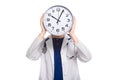 Young woman doctor with stethoscope in trouble holding clock in front of her head in white uniform on white background Royalty Free Stock Photo