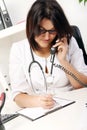 Young woman doctor talking by phone Royalty Free Stock Photo