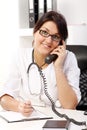 Young woman doctor talking by phone Royalty Free Stock Photo