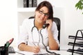 Young woman doctor talking by phone Royalty Free Stock Photo