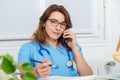 Young woman doctor talking on phone Royalty Free Stock Photo