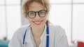 Young woman doctor wearing glasses smiling at the clinic Royalty Free Stock Photo