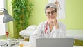 Young woman doctor wearing glasses smiling at clinic Royalty Free Stock Photo