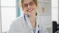 Young woman doctor wearing glasses smiling at the clinic Royalty Free Stock Photo