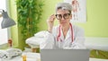 Young woman doctor wearing glasses smiling at clinic Royalty Free Stock Photo