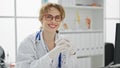 Young woman doctor wearing gloves smiling at the clinic Royalty Free Stock Photo