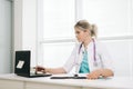 Young woman doctor woman working on laptop in office. Royalty Free Stock Photo