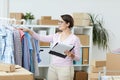 Young woman with document looking through new collection of casualwear Royalty Free Stock Photo