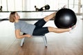 A young woman does abs exercises in the gym on a bench using a fitball. The concept of sports and a healthy lifestyle Royalty Free Stock Photo