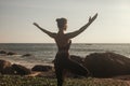 Young woman does yoga for healthy lifestyle on sea beach Royalty Free Stock Photo