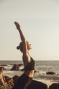 Young woman does yoga for healthy lifestyle on sea beach Royalty Free Stock Photo
