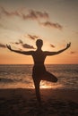 Young woman does yoga for healthy lifestyle on sea beach Royalty Free Stock Photo