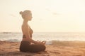 Young woman does yoga for healthy lifestyle on sea beach Royalty Free Stock Photo