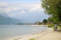 Young woman and a dog jogging along the lake Como beach. Royalty Free Stock Photo