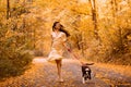 Young woman with the dog in the park. Wind in the hair. With dog on a walk in an autumn nature. Young beautiful female Royalty Free Stock Photo