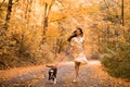 Young woman with the dog in the park. Wind in the hair. With dog on a walk in an autumn nature. Young beautiful female